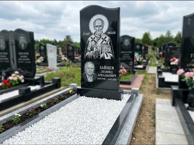 Памятник с гравировкой иконы: стела с крестообразным навершием — икона в резной рамке-киоте, газон без ограды, стриженая трава, работа «Раевская» в Красноярске