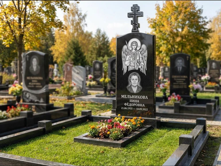 Памятник с гравировкой иконы: округлая стела-медальон с ликом — гравировка Богородицы «Семистрельная», луговые травы и полевые цветы за участком, работа «Гущин» в Красноярске