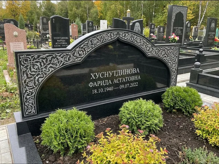 Мусульманский памятник: вытянутая горизонтальная семейная стела с аркой — белая гравировка силуэта мечети с минаретами, участок с декоративными кустами, работа «Зарипова» в Красноярске
