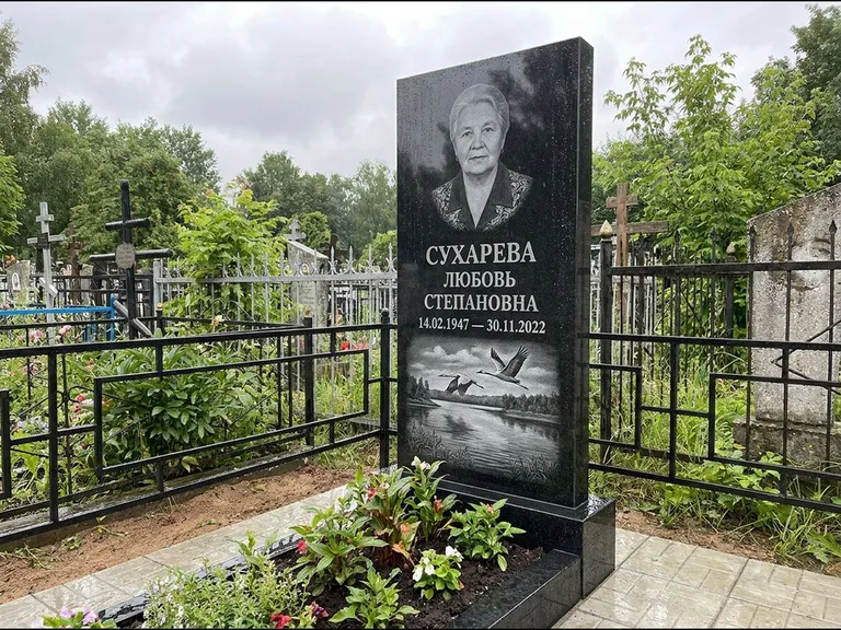 Памятник с гравировкой журавлей — гравировка пары журавлей над гладью озера в нижней части, работа «Сухарева» в Красноярске