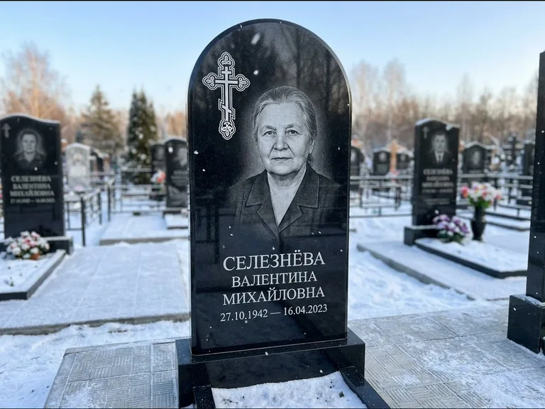 Памятник из чёрного гранита — массивная стела с крестом в лучах с крестом в лучах, работа «Одинцова» в Красноярске