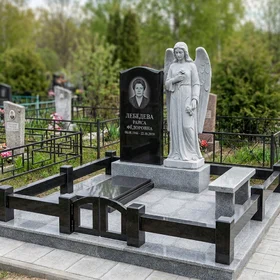 Высокий памятник из чёрного гранита со скульптурой ангела